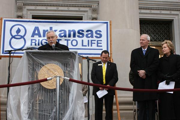 Bishop Anthony B. Taylor prays at the start of the March for Life program on the State Capitol steps. Gov. Asa Hutchinson and First Lady Susan Hutchinson and Rep. Andy Mayberry, president of Arkansas Right to Life, listen. (Malea Hargett photo)