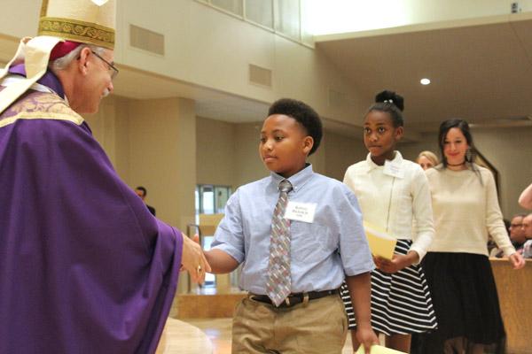 Rodney Nichols Jr. shakes Bishop Taylor’s hand during the Rite of Election. Nichols is a catechumen at Immaculate Heart of Mary Church in North Little Rock (Marche)  (Dwain Hebda photo)