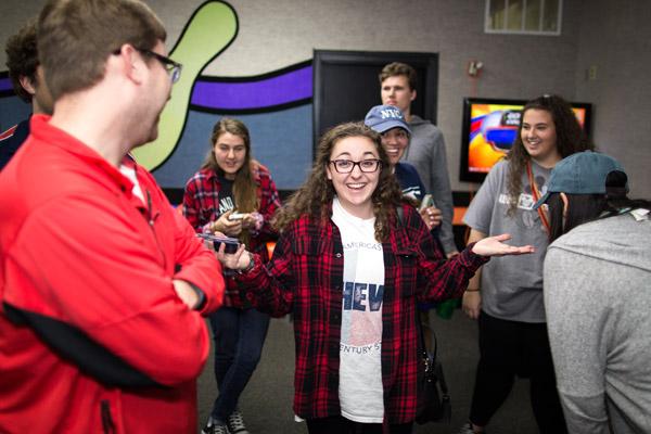 Christa Murad jokes with her friends from St. Thomas Aquinas University Parish in Fayetteville during a March 2 group outing to Ozark Lanes for bowling and fellowship. (Travis McAfee photo)