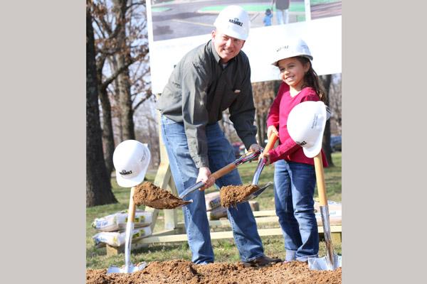 Parish business manager John Street helps parishioner Ana Mata, 8, shovel dirt after the March 19 groundbreaking ceremony for the new Blessed Sacrament Church at 1105 E. Highland Drive. (Sarah Morris photo)
