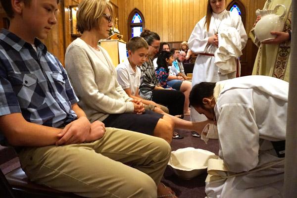 Father Rubén Quinteros, pastor at Immaculate Heart of Mary Church in North Little Rock (Marche), washes the feet of parishioner Justin Dobry, 14, during Holy Thursday Mass April 13. (Aprille Hanson photo)