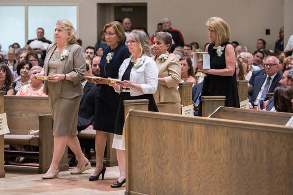 Theresa Burmester (left), Sandra Lacayo, Madelyn Womack, Evelyn Hart and Lisa Siebold, mothers of the newly ordained priests, bring the gifts to the altar during the ordination. (Travis McAfee photo)