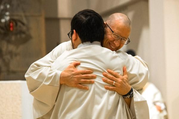 Deacon Danny Hartnedy embraces Deacon Stephen Elser during the ordination Mass. (Bob Ocken photo)