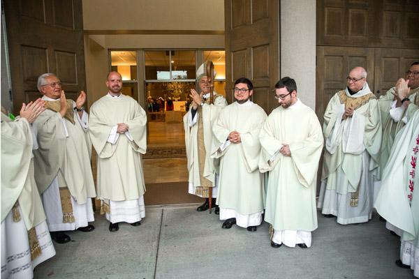 Bishop Taylor and priests applaud as the new deacons exit Christ the King Church after the ordination. (Bob Ocken photo)
