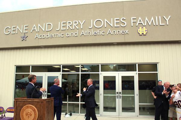 While other dignitaries mingle, Jerry Jones (far right) shares a selfie with students immediately after unveiling the new academic/athletic annex at Catholic High School. (Dwain Hebda photo)