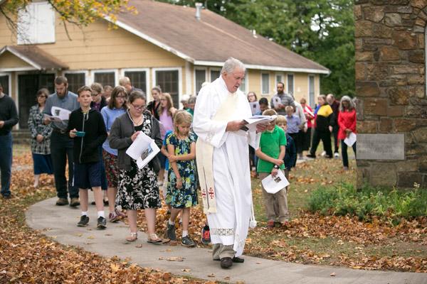Deacon Mike Henry leads pilgrims back to the church of Our Lady of the Ozarks at the conclusion of their pilgrimage and rosary on the grounds of the shrine. (Karen Schwartz photo)