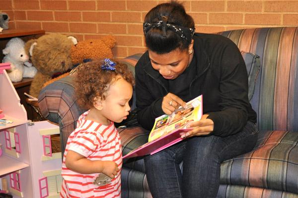 Alex reads to Olivia, then 16 months old, from a book created by her adoptive parents Rebecca and Michael that tells the story of her adoption. Alex, Olivia's birth mother, visits with the family at least once a year. 