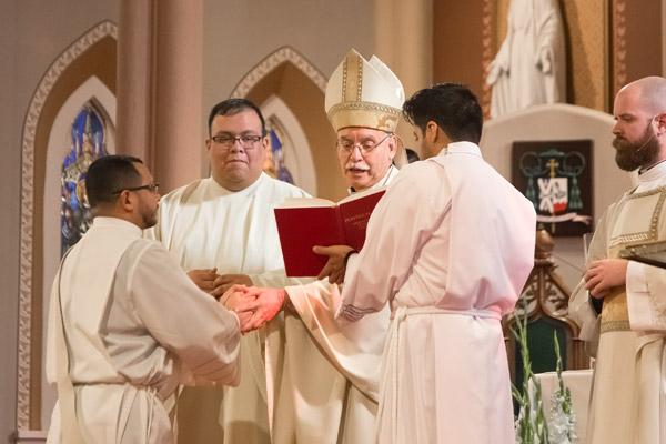 Father Nelson Rubio makes a promise to Bishop Anthony B. Taylor of “respect and obedience” to him and his successors during his Dec. 16 priestly ordination. Father Juan Guido (left) served as master of ceremonies, Deacon Patrick Friend (right) was deacon of the Word and seminarian Jaime Nieto assisted the bishop. (Bob Ocken photo)