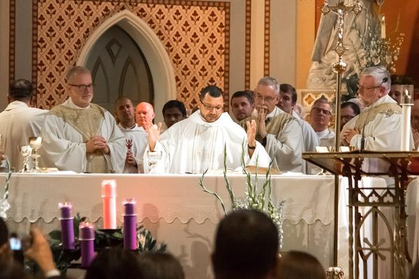 Father Nelson Rubio tears up while reading the Eucharistic prayer during his ordination Dec. 16. Msgr. Scott Friend (left) and Father Mark Wood (right) were important spiritual leaders for Father Rubio. (Bob Ocken photo)