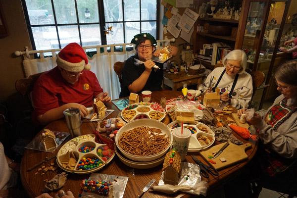 Heath Davis, 15, proudly holds up his graham cracker cookie house on Dec. 21. Jean Leffler (far right) and her husband Dave, parishioners at St. Joseph Church in Conway, have hosted friends and family at their home for 31 years to make Christmas cookie houses. Others pictured are Hunter Davis and Nancy Frevert. (Aprille Hanson photo)