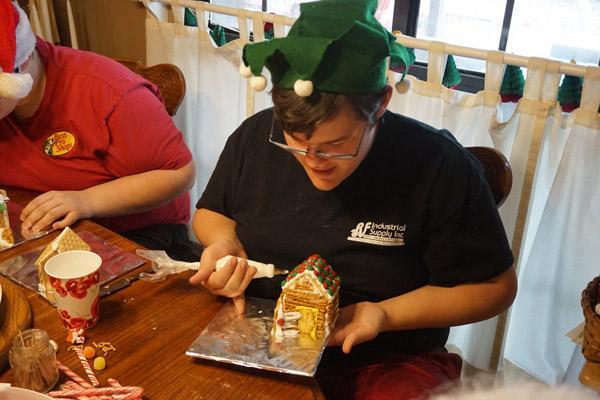 Heath Davis carefully adds more icing to his log cabin. Heath and his twin brother Hunter have been making Christmas cookie houses with their grandmother since they were toddlers. (Aprille Hanson photo)