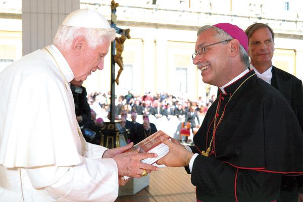 While in Rome for the diaconate ordination of then-seminarian Andrew Hart, Bishop Anthony B. Taylor attends the general papal audience Oct. 5, 2011, and gives Pope Benedict XVI a hardback copy of the new Little Rock Study Bible, which was first published that summer by Little Rock Scripture Study. (Courtesy L’Osservatore Romano)