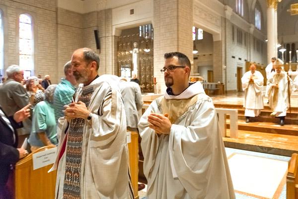 Fathers Reginald Udouj (left) and Cassian Elkins process out of St. Benedict Church at Subiaco Abbey following their ordination Mass July 14. (Bob Ocken photo)