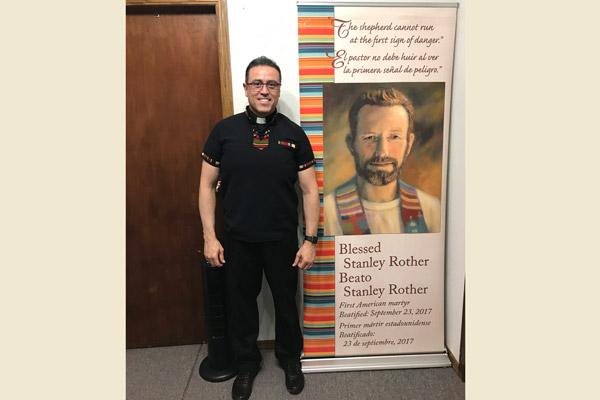 Pastor Father Salvador Márquez-Muñoz stands by a banner honoring Blessed Stanley Rother, patron of the church in Decatur. Parishioners celebrated his feast day Mass July 28. (Courtesy Father Salvador Marquez-Munoz)