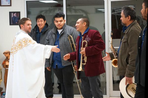 Pastor Father Stephen Hart greets the Tamborazo Zacatecano de Arkansas band before they begin performing after Mass. (Malea Hargett photo)
