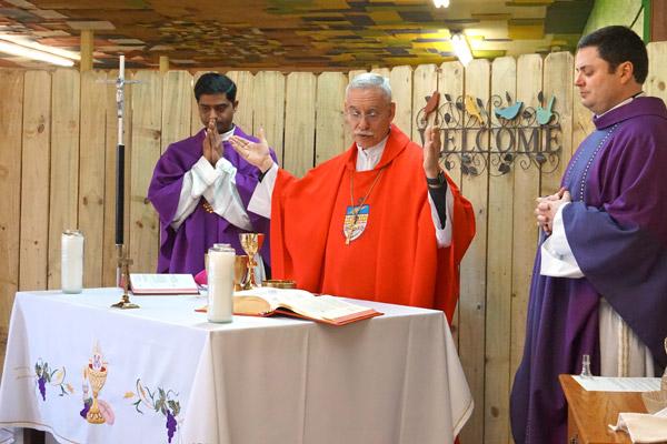 Bishop Taylor celebrates the Liturgy of the Eucharist with Pastor Father Tony Robbins (right) and associate pastor Father Chandra Kodavatikanti at the St. Oscar Romero Catholic Community in Greenbrier March 16. (Aprille Hanson photo)