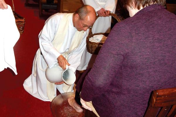 Father William Elser washes a parishioner’s feet at Sacred Heart of Jesus Church during Holy Thursday Mass April 18 in Hot Springs Village. (Jim Keary photo)