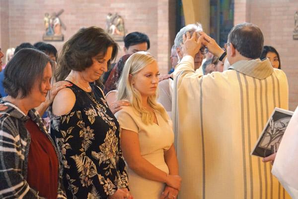 Father Norbert Rappold, pastor of St. Peter the Fisherman Church in Mountain Home, blesses candidate Harriett Feulner during confirmation at Easter Vigil Mass April 20 in photo above. Other candidates pictured are Carol McClain (left), Nancy Bemus and Ashton Garner. (Aprille Hanson photo)