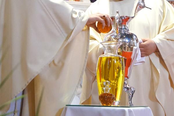Bishop Taylor pours the fragrance into the olive oil to create the sacred chrism before consecrating it at the Chrism Mass. Chrism is the only oil of the three to be consecrated with the Holy Spirit. (Aprille Hanson photo)