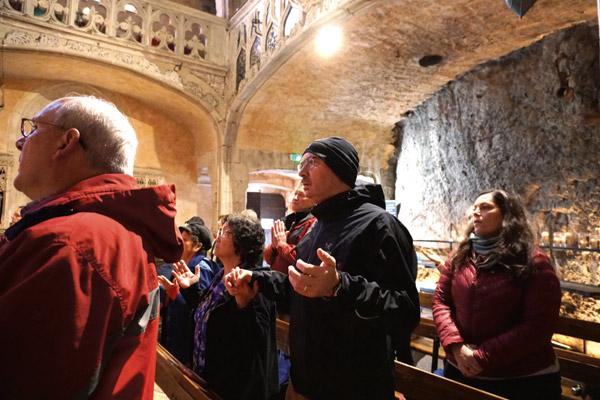 Mitch and Cathy Carter, members of Our Lady of Good Counsel Church in Little Rock, and Kathy Primm, of North Little Rock, who served as the travel agent for the pilgrimage, pray the Our Father April 4 at the chapel in Rocamadour, a pilgrimage site for centuries. (Malea Hargett photo)