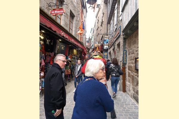 Father T.J. Hart and Rena Harrison, a member of St. Joseph Church in Pine Bluff, walk the pedestrian street of Mont St. Michel, looking at the restaurants and shops. Some pilgrims climbed up 1,000 steps to see the Benedictine church at the top. (Malea Hargett photo)
