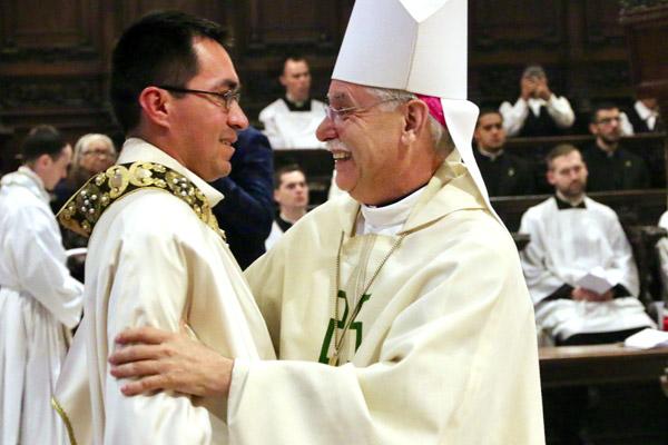 Bishop smiles and hugs Father Amaro during his priestly ordination May 11 in St. Peter Basilica at the Vatican. (Denis Nakkeeran photo, Pontifical North American College)
