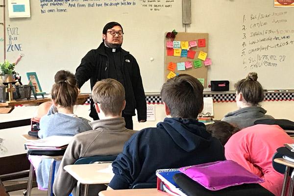 Father Stephen Elser, 28, answers questions about faith and morality from eighth-grade religion students at Fort Smith’s Trinity Junior High School in October. He said it’s important to be himself and show how normal it is to be a priest. (Courtesy Eileen Teagle, Trinity Junior High)