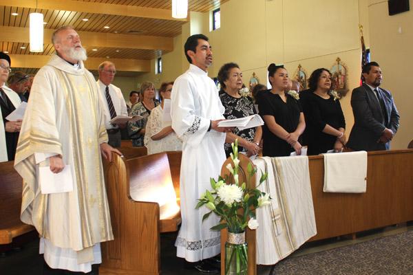 Daniel Velasco, center, sings along with his family and Vocations Director Msgr. Scott Friend (left) during Velasco’s May 17 diaconate ordination Mass in Searcy. (Dwain Hebda photo)
