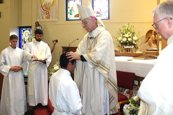 Bishop Anthony B. Taylor lays his hands on Daniel Velasco, ordaining him a transitional deacon. Velasco is the first vocation produced by St. James Church in Searcy. (Dwain Hebda photo