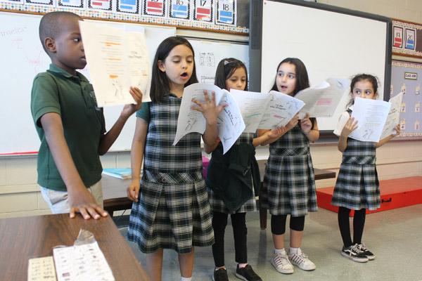A group of Amanda Bridges' second-graders entertain their classmates at St. Edward School in Little Rock with a reading of the appropriately-titled "I'll Be The Dragon." They are (from left) Bonito Jovonang, Alysson Rodriguez, Fatima Gonzalez, Baylee Garcia and Daniela Ventura. (Dwain Hebda photo)