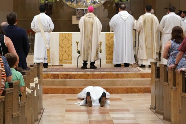 As the congregation sings the Litany of the Saints, Joseph Friend lays prostrate before the altar. (Malea Hargett photo)