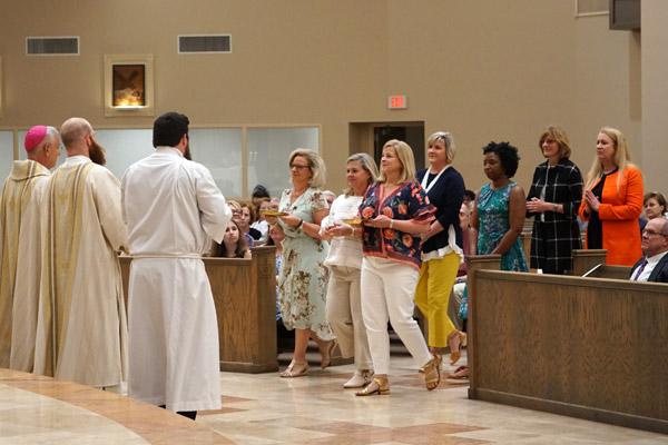 Seven friends of Joseph Friend's late mother Betty were chosen to bring up the gifts during Mass. (Malea Hargett photo)