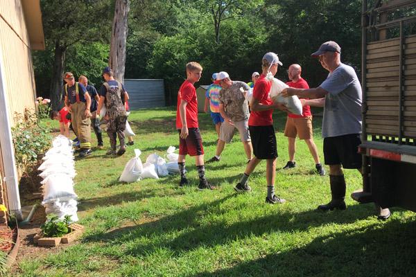 Youth from New Life Church in Greenbrier and members of the Greenbrier Fire Department help stack sandbags along the home of Bruce and Juanita Noah, members of St. Joseph Church in Conway, June 1. (Courtesy Juanita Noah)