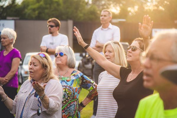 Some of the more than 100 people who gathered to pray in front of the former Planned Parenthood clinic in Fayetteville include Molly Mays (at left with hands open) and Merry Beth Anderson (with hands raised). (Travis McAfee photo)