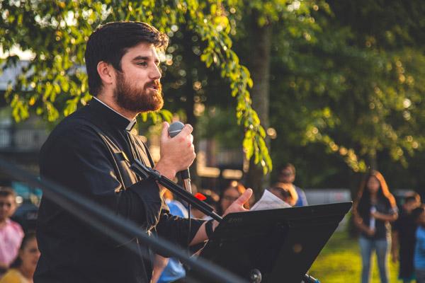 Father Jon Miskin, associate pastor of St. Raphael Church in Springdale, offers the closing prayer July 25, exhorting the people, "If you have any doubt as to the power and faithfulness of God, remember this night." (Travis McAfee photo)