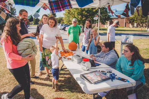 Eighth grader Bree McAfee finds her prized pumpkin among the hundreds to choose from as others look on in awe. (Travis McAfee photo)