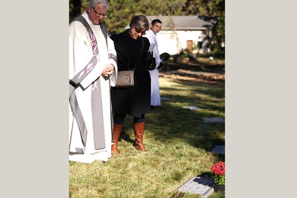 Msgr. Francis I. Malone and Jan Brass, a retired diocesan employee, look at the headstone of Msgr. Bernard Malone, Msgr. Malone's uncle, who died in 2017. (Malea Hargett photo)