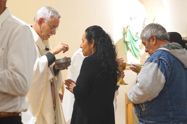 Bishop Anthony B. Taylor distributes Communion during the bilingual Mass Nov. 23 at St. Luke Church in Warren. (Malea Hargett photo)