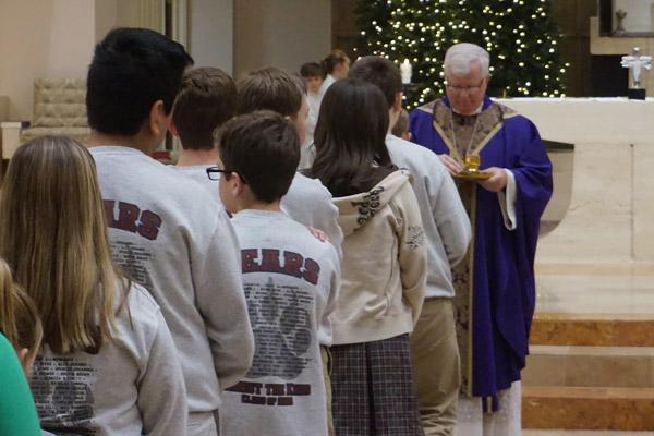 Bishop-elect Malone has been a spiritual father to students at Christ the King School for nearly 19 years. Students lined up for Communion during his final school Mass Dec. 20. (Aprille Hanson photo) 