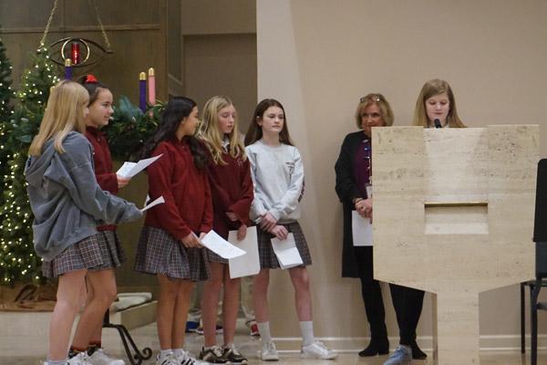 Seventh grader Abbey Barnes shares what she will miss most about Bishop-elect Malone as other students wait to share memories and give him advice following his final school Mass Dec. 20. (Aprille Hanson photo) 