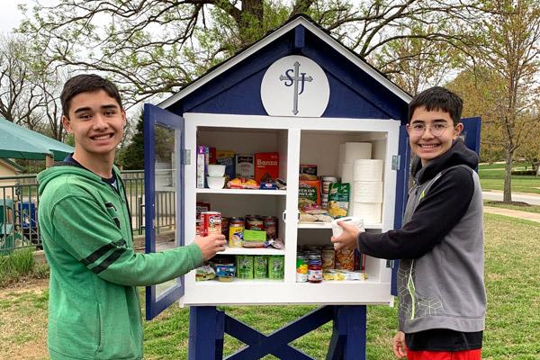 Spencer Katz (left) and his brother Riley Katz, both 14, smile after stocking the Little Free Pantry at St. Joseph Church in Fayetteville. A note was recently found taped to the pantry, thanking those who donate. (Judy Katz photo) 