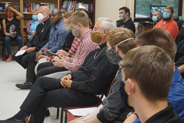 Bishop Anthony B. Taylor (center), vocations director Msgr. Scott Friend (left) and seminarians listen and pass around an Aunt Jemima syrup bottle as Father Warren Harvey discusses racism at the House of Formation in Little Rock July 2. (Aprille Hanson photo)