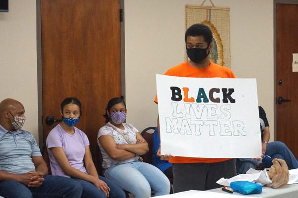 Caleb Hamilton, a parishioner at Immaculate Conception Church in North Little Rock, holds up a Black Lives Matter sign during the racism dialogue at the House of Formation in Little Rock. The Diocesan Council for Black Catholics discussed the true meanings of phrases like this. (Aprille Hanson photo)