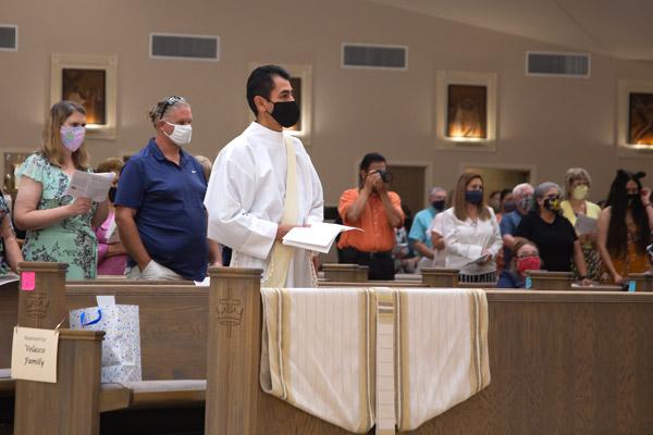 Father Daniel Velasco stands alone in his pew at Christ the King Church in Little Rock for his ordination. Customarily, family sits beside those being ordained. Because of the COVID-19 pandemic, Father Velasco’s family could not travel from Mexico, but watched via livestream. (Bob Ocken photo)