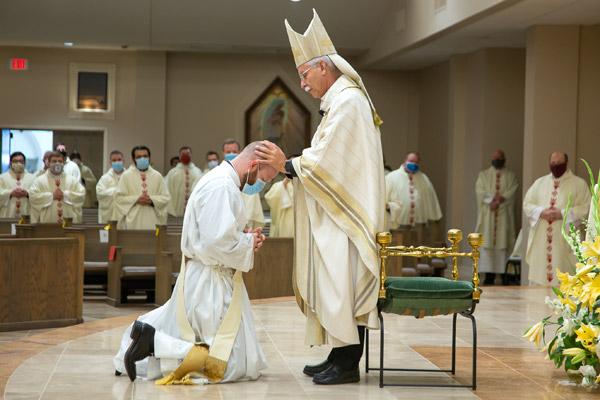 Bishop Anthony B. Taylor lays hands on Father Joseph Friend, a tradition to receive the strength of the Holy Spirit during his priestly ordination. 