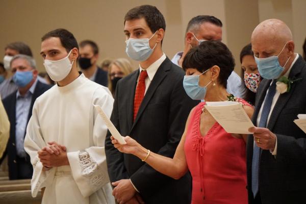 Ben Riley stands with his brother, Zach, and parents, Dr. Richard and Melanie Riley, at the beginning of his diaconate ordination Mass Aug. 14 at Christ the King Church in Little Rock. (Malea Hargett photo)