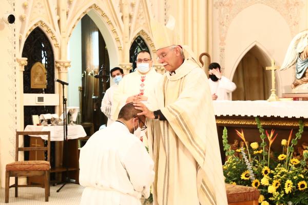 Bishop Anthony B. Taylor places his hands on seminarian Emmanuel Torres, ordaining him a transitional deacon. The ordination Mass was celebrated Aug. 13 at St. Edward Church in Little Rock. (Dwain Hebda photo)