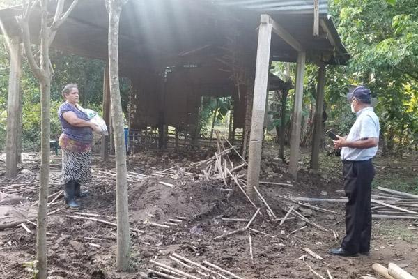 Father Gildo Ramírez, with the Diocese of Trujillo, speaks with a woman Nov. 12 by a structure that was destroyed. Flooding from two hurricanes in the space of two weeks -- Eta and Iota -- washed away houses, roads and bridges. (Courtesy Father Gildo Ramírez)