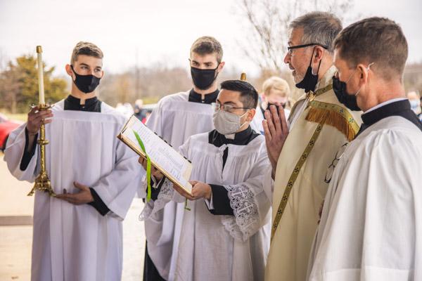 Father John Connell prays during the dedication, assisted by Father Joshua Passo, FSSP. (Travis McAfee photo)