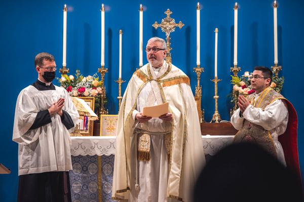Father John Connell reads the proclamation from Bishop Anthony B. Taylor erecting Our Lady of Sorrows Parish. The bishop was in isolation after testing positive for COVID-19 Dec. 10 and could not attend. (Travis McAfee photo)